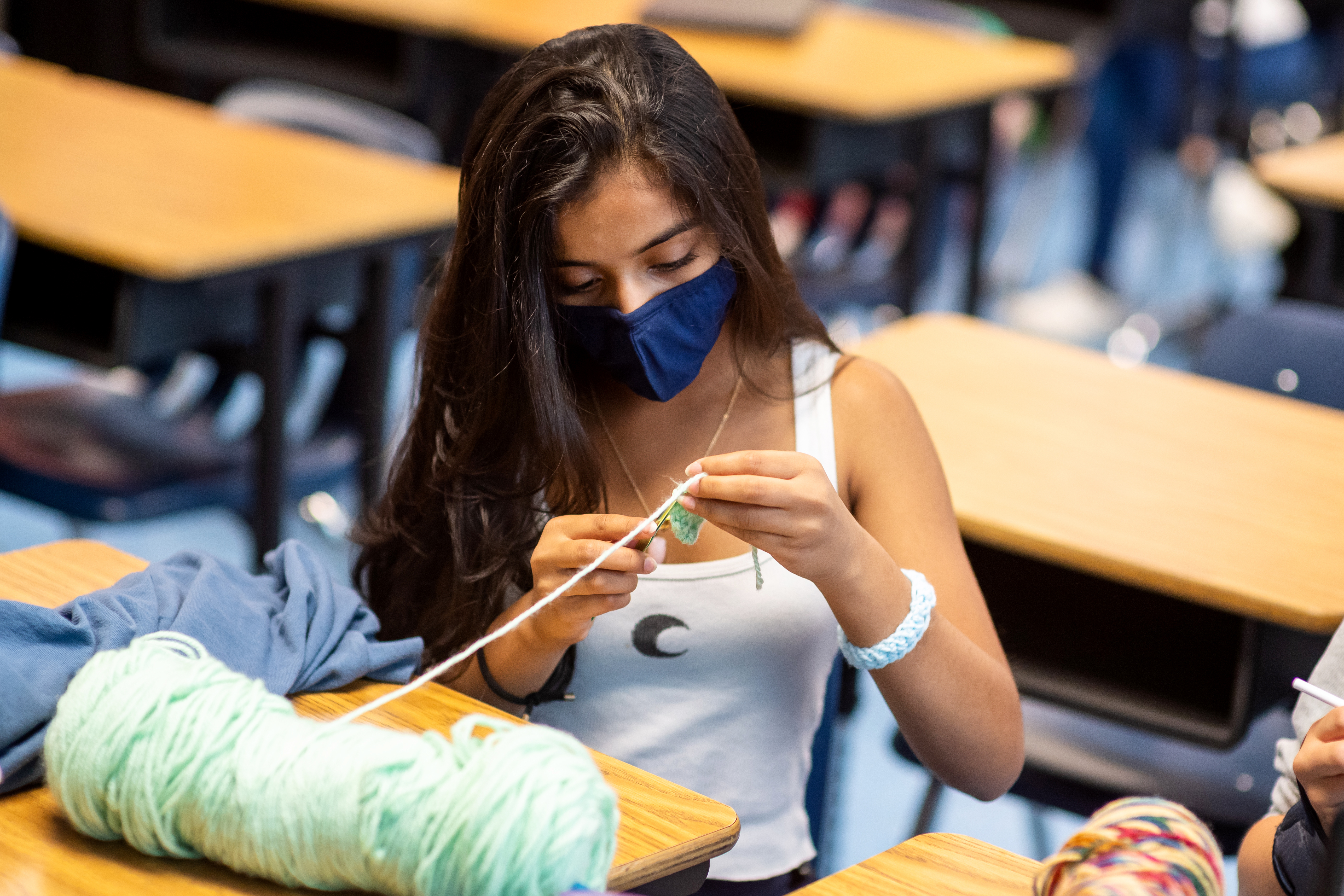 A Katherine Johnson Middle School student is learning to crochet as part of a social-emotional learning time period intended to help students build relationships with staff and pursue enrichment activities.