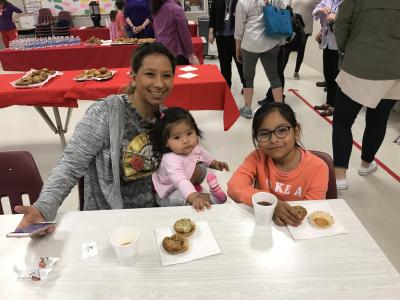 photo of mother and daughters enjoying muffins